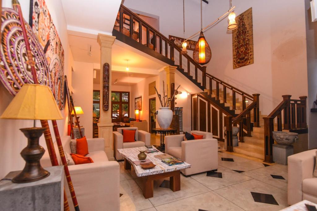 Gangula Villa lobby and staircase with ornate wood railings and art