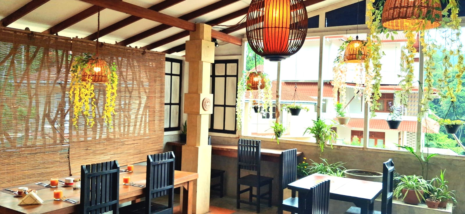 Gangula Villa restaurant interior — rattan pendant lights, wooden dining tables and lush garden views